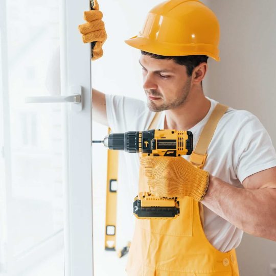 handyman-in-yellow-uniform-installs-new-window-e1663969295597.jpg